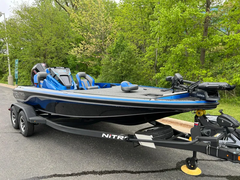 Slide: The Image of 2025 Nitro Z19 Pro boat on trailer, parked near lush green trees. - 2
