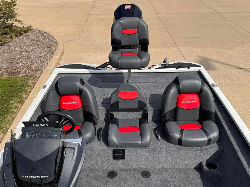 Slide: The Image of 2025 Tracker Savage 215 boat interior with red and black seating, Garmin system visible. - 3