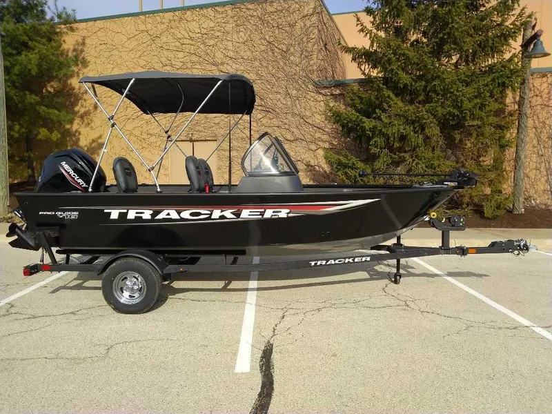 The Image of 2025 Tracker Pro Guide V-16 WT boat on trailer, parked outdoors. - 0