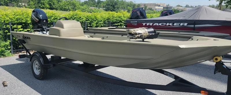 Slide: The Image of 2025 Tracker Grizzly 1754 SC boat on trailer, parked outdoors, with motor and cover. - 3