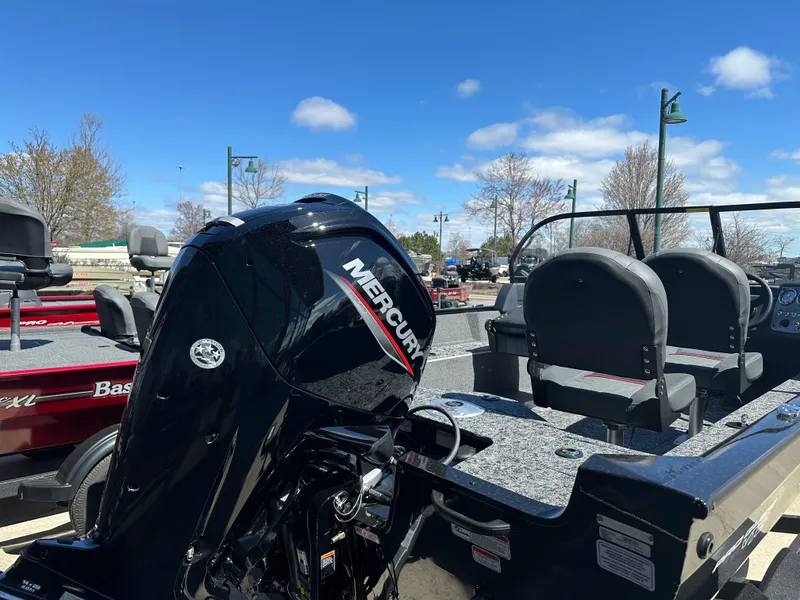 Slide: The Image of 2025 Tracker Pro Guide V-16 WT boat with Mercury engine, parked outdoors under blue sky. - 4