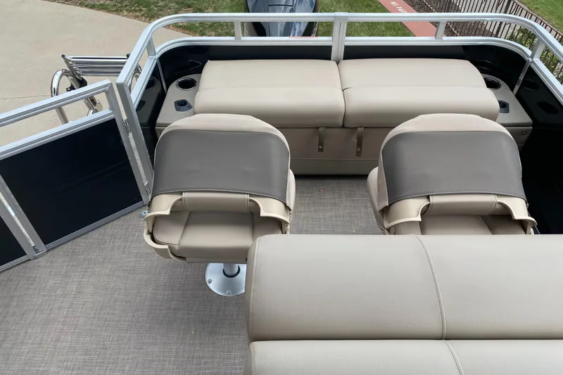 Slide: The Image of 2025 Sun Tracker SportFish 22 XP3 boat interior with beige seating and cup holders. - 5