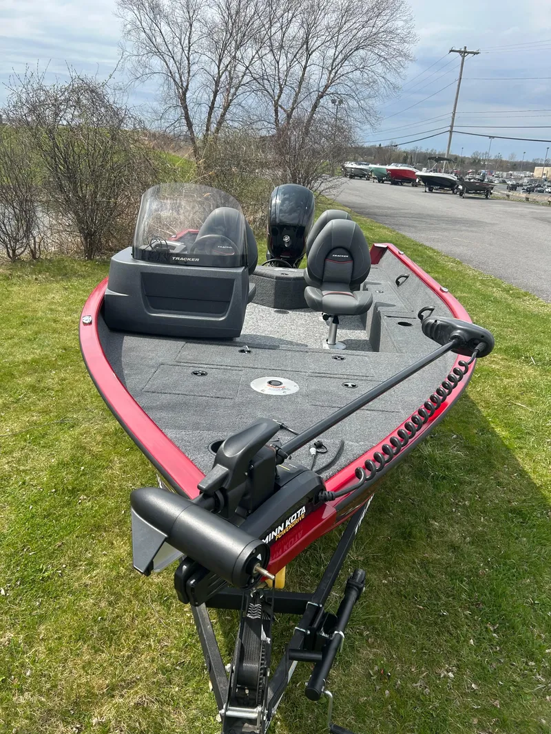 Slide: The Image of 2025 Tracker Pro Guide V-16 SC boat on grass, featuring a sleek red design and modern equipment. - 2
