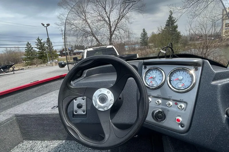 Slide: The Image of 2025 Tracker Pro Guide V-16 SC boat dashboard with steering wheel and gauges. - 3