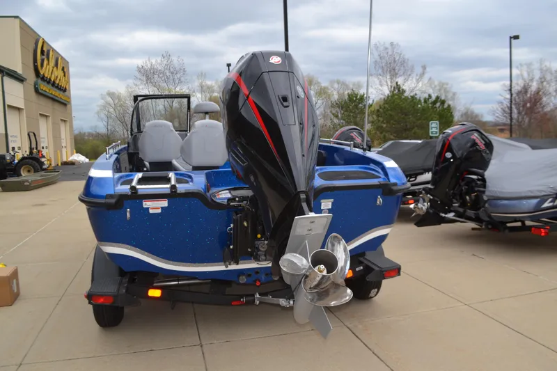 Slide: The Image of 2025 Nitro ZV19 Pro boat with powerful outboard motor, parked outdoors on a cloudy day. - 2