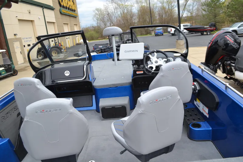 Slide: The Image of 2025 Nitro ZV19 Pro boat interior with Garmin system, featuring gray seats and blue accents. - 3