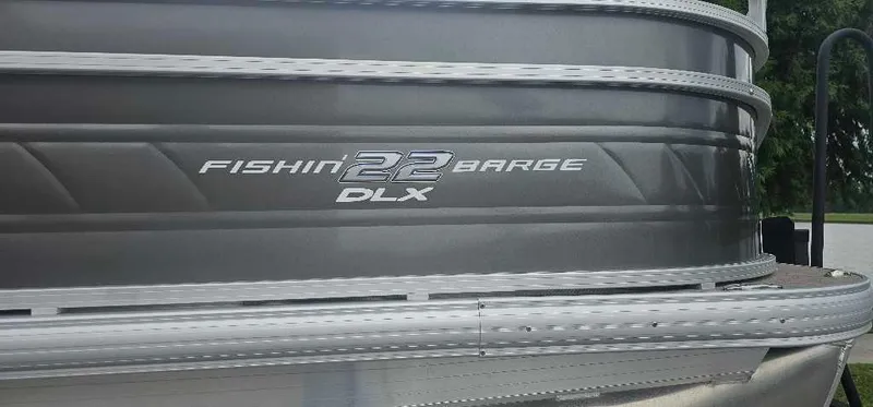 Slide: The Image of 2025 Sun Tracker Fishin' Barge 22 DLX, gray exterior detail. - 2