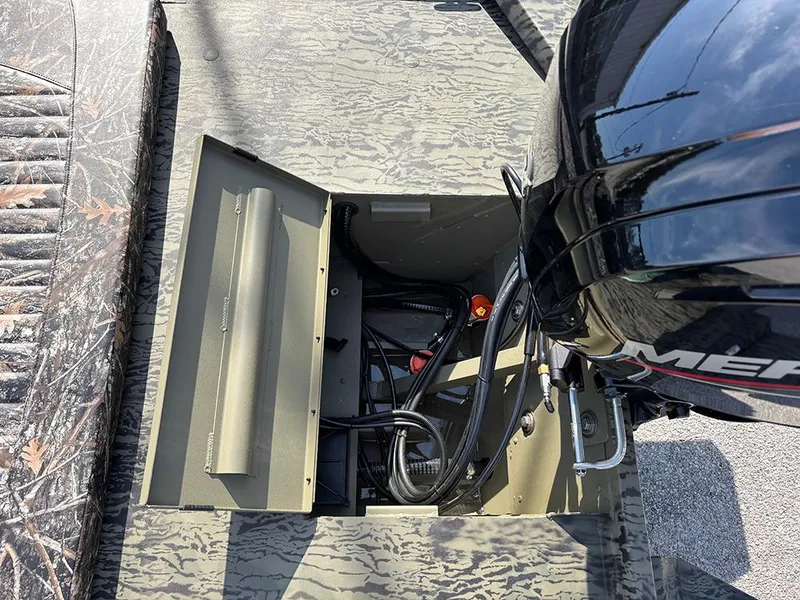 Slide: The Image of 2025 Tracker Grizzly 1860 CC boat engine compartment with visible wiring and components. - 15