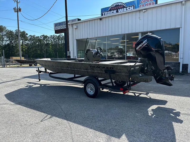Slide: The Image of 2025 Tracker Grizzly 1860 CC boat on trailer, parked outside a building. - 2