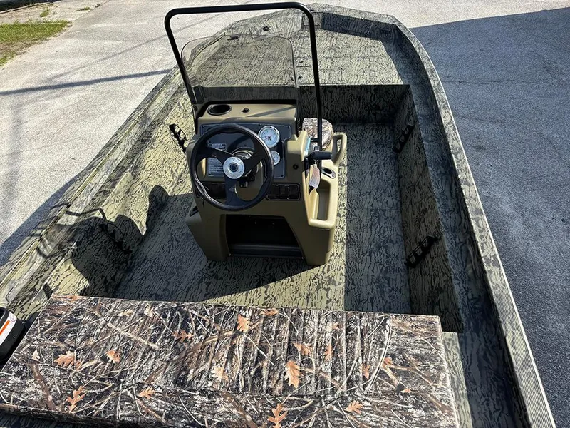 Slide: The Image of 2025 Tracker Grizzly 1860 CC boat interior with camouflage design and steering console. - 8
