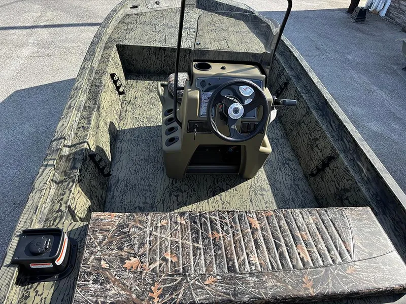 Slide: The Image of 2025 Tracker Grizzly 1860 CC boat interior with camouflage design and steering console. - 9