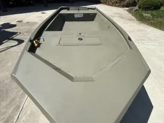 Slide: The Image of 2025 Tracker Grizzly 1648 Jon boat on concrete surface, showcasing its spacious interior. - 2