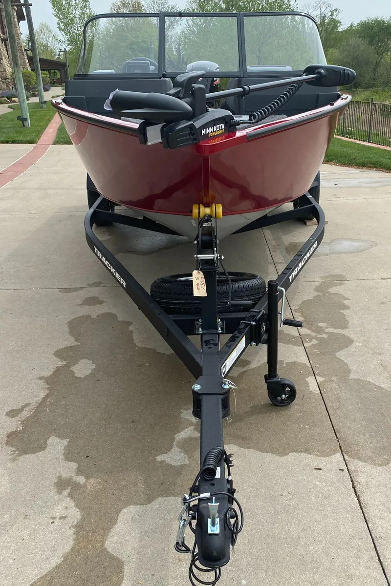 Slide: The Image of 2025 Tracker Pro Guide V-175 WT boat on trailer, red exterior, parked on concrete. - 2