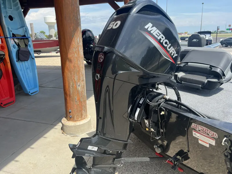 Slide: The Image of 2025 Tracker Bass Tracker Classic XL with Mercury outboard motor, displayed outdoors. - 2