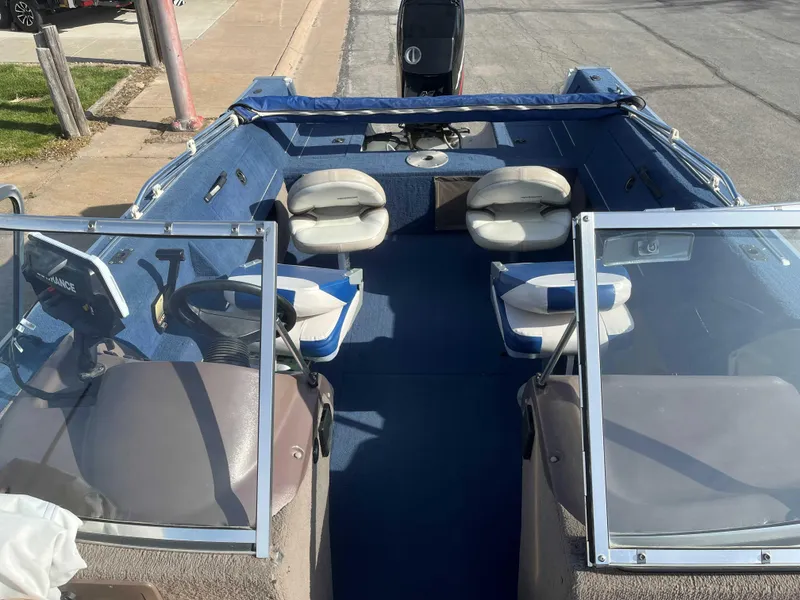 Slide: The Image of 2000 Starcraft 176 Super Fisherman boat interior with blue seating and dual consoles. - 2