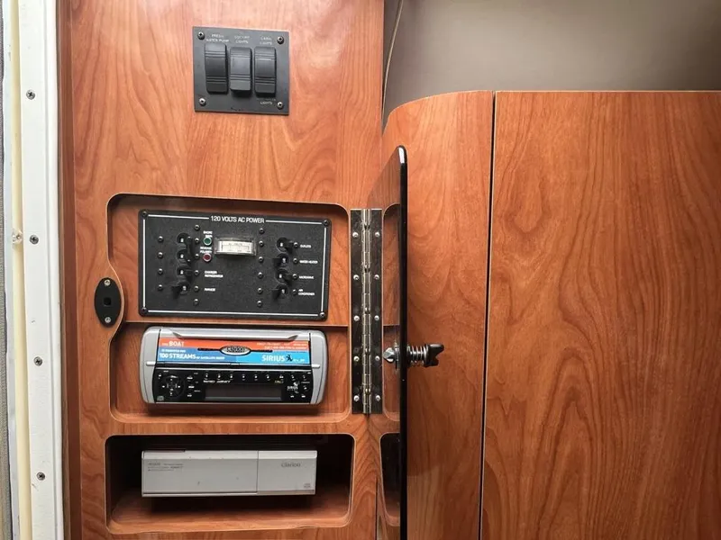 Slide: The Image of Control panel inside 2004 Four Winns 248 Vista boat, featuring switches and audio system. - 17