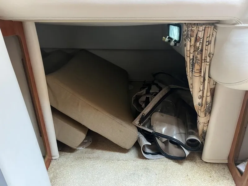 Slide: The Image of Interior storage area of a 2004 Four Winns 248 Vista boat with cushions and curtains. - 21