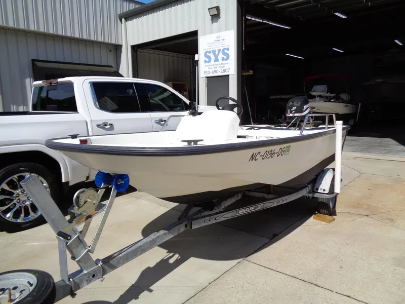 Slide: The Image of 2000 Boston Whaler 13 Sport boat on trailer, parked outside a garage. - 2