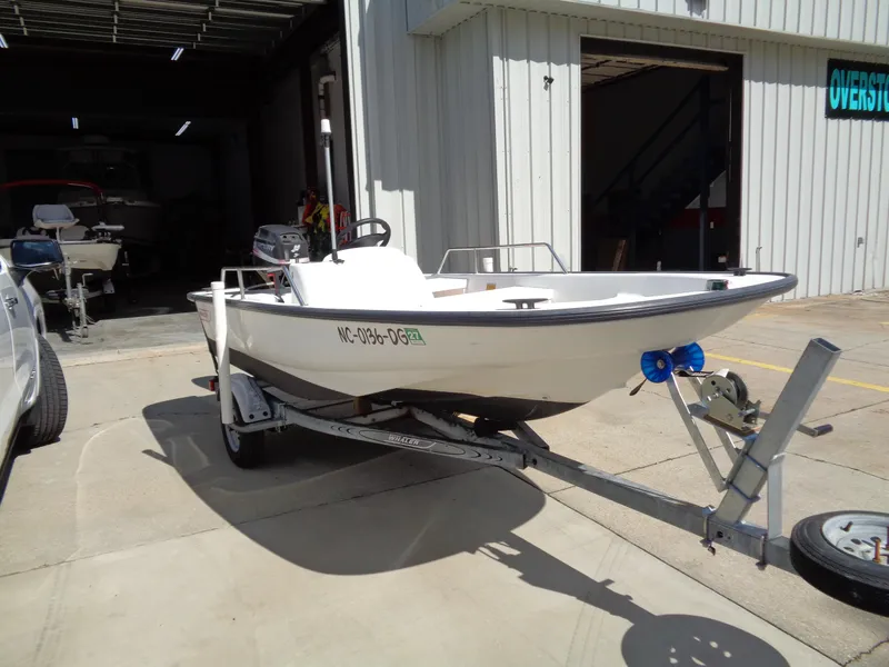 Slide: The Image of 2000 Boston Whaler 13 Sport boat on trailer outside a garage. - 3