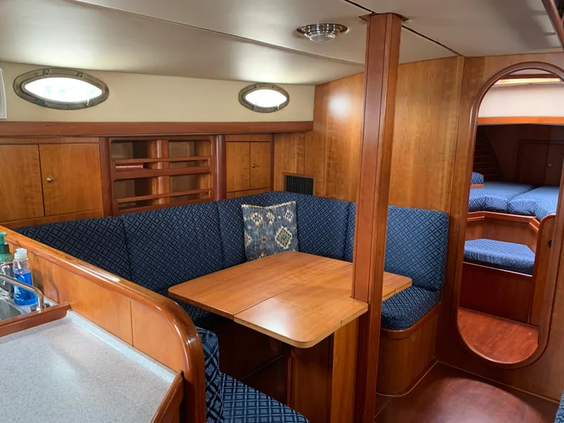 Slide: The Image of Luxurious ShearWater 45 yacht interior, featuring a cozy dining area with blue upholstered seating. - 6