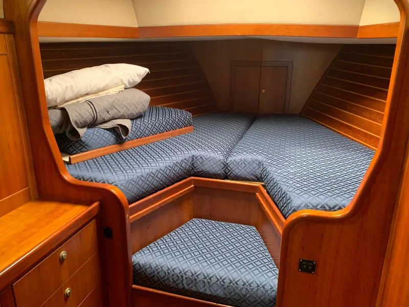 Slide: The Image of Cozy cabin interior of 2004 ShearWater 45 yacht with blue bedding and wooden finish. - 7
