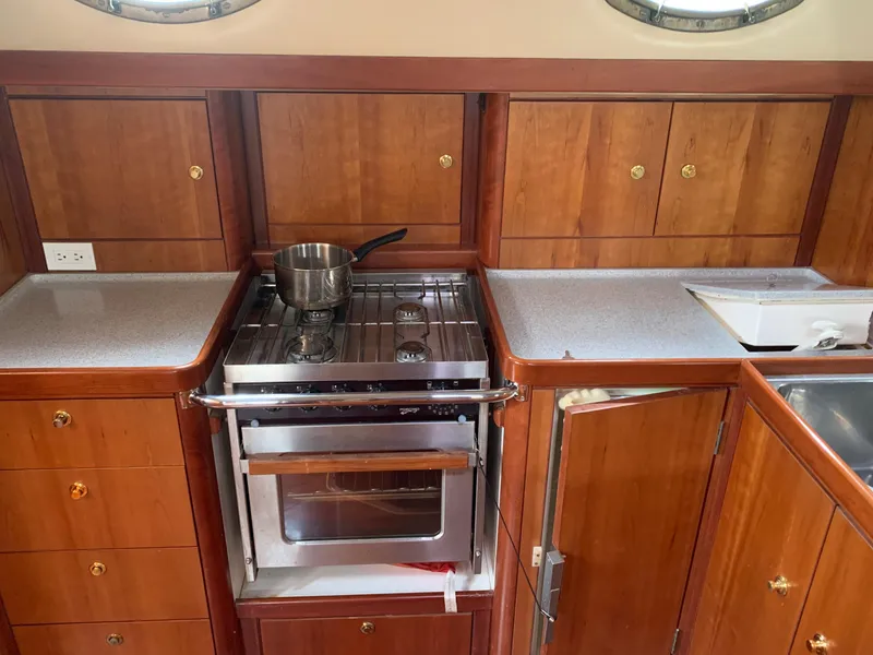 Slide: The Image of Galley kitchen in 2004 ShearWater 45 yacht with stove, oven, and wooden cabinetry. - 9