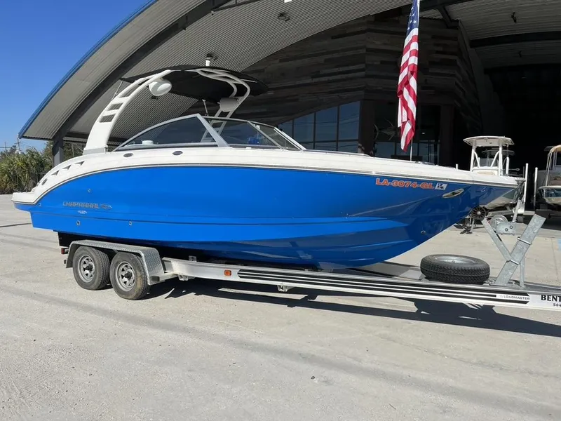 Slide: The Image of 2018 Chaparral 244 Sunesta Xtreme boat on trailer, blue hull, parked outdoors. - 7
