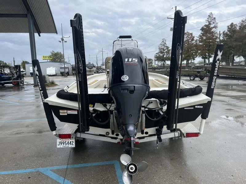 Slide: The Image of 2023 Xpress H20 BAY boat with powerful outboard motor, parked on a wet surface. - 4