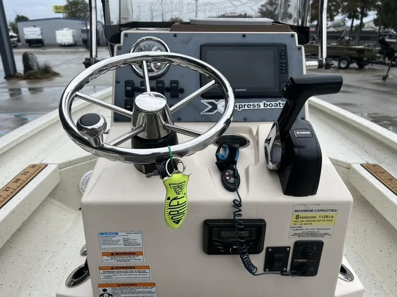 Slide: The Image of 2023 Xpress H20 BAY boat console with steering wheel, controls, and Garmin display. - 7