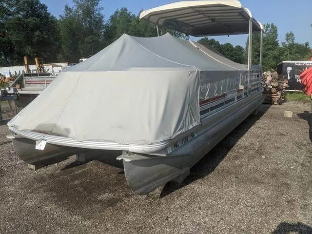 Slide: The Image of 1992 Harris 280 Heritage pontoon boat covered, parked on gravel, surrounded by trees. - 1