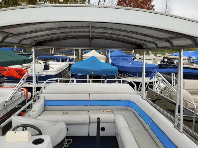Slide: The Image of 1992 Harris Sunliner pontoon boat with canopy, docked among other covered boats. - 10