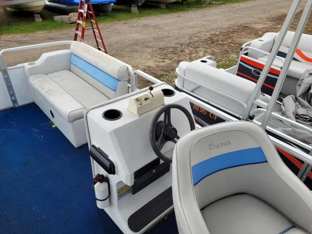 Slide: The Image of 1992 Harris Sunliner pontoon boat interior with blue and white seating and steering console. - 18