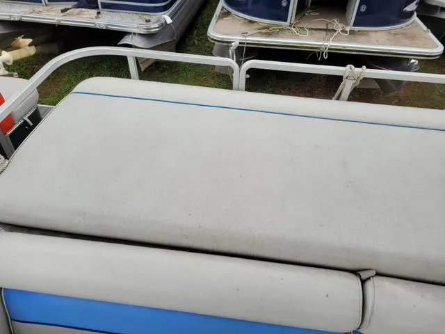 Slide: The Image of 1992 Harris Sunliner boat seat with blue accents, surrounded by other boats. - 8