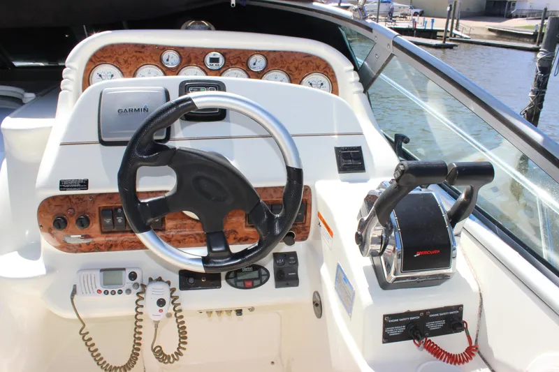 Slide: The Image of 2005 Larson Cabrio 310 boat dashboard with steering wheel and control panel. - 14