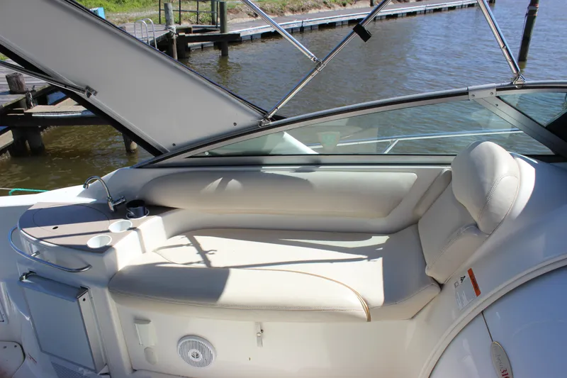 Slide: The Image of 2005 Larson Cabrio 310 boat interior with white seating and cup holders. - 15