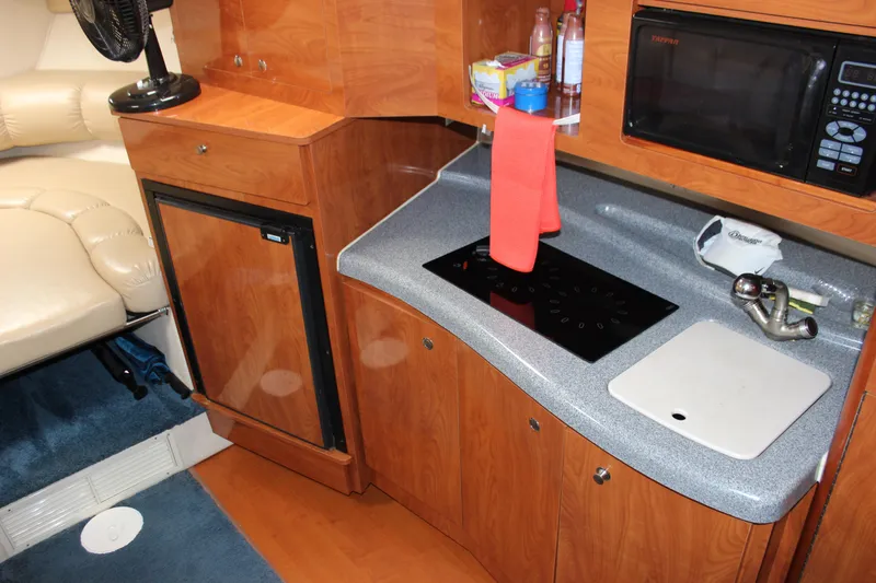 Slide: The Image of 2005 Larson Cabrio 310 boat kitchen with microwave, stove, and fridge. - 19