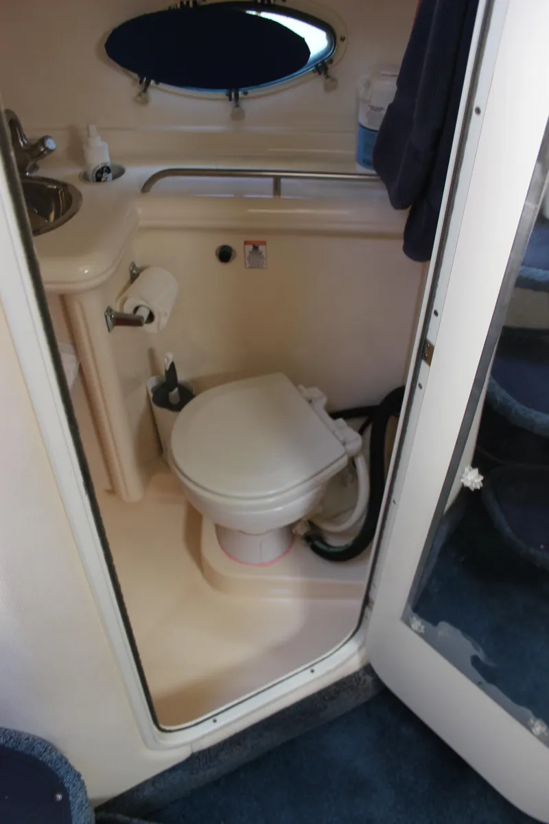 Slide: The Image of 2005 Larson Cabrio 310 boat bathroom with toilet, sink, and mirror. - 20