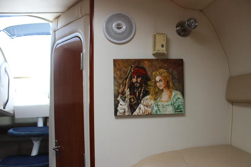 Slide: The Image of 2005 Larson Cabrio 310 cabin interior with pirate-themed artwork on the wall. - 25