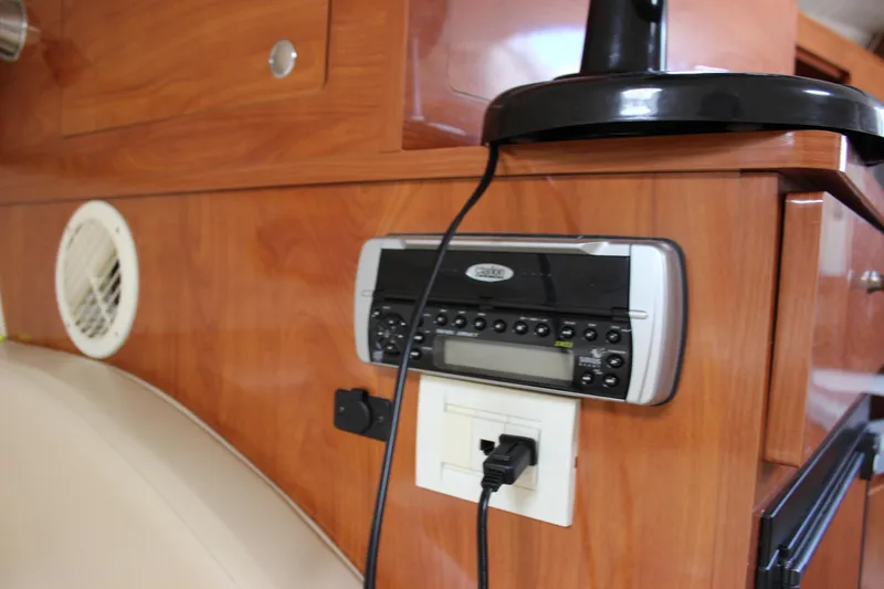 Slide: The Image of 2005 Larson Cabrio 310 interior with stereo system and wooden cabinetry. - 26