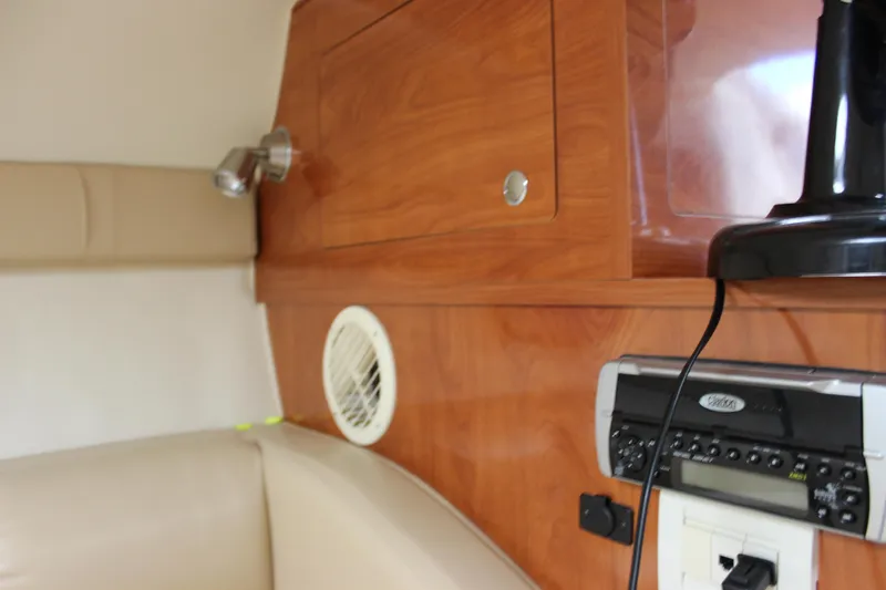 Slide: The Image of 2005 Larson Cabrio 310 cabin interior with wood paneling and audio system. - 27