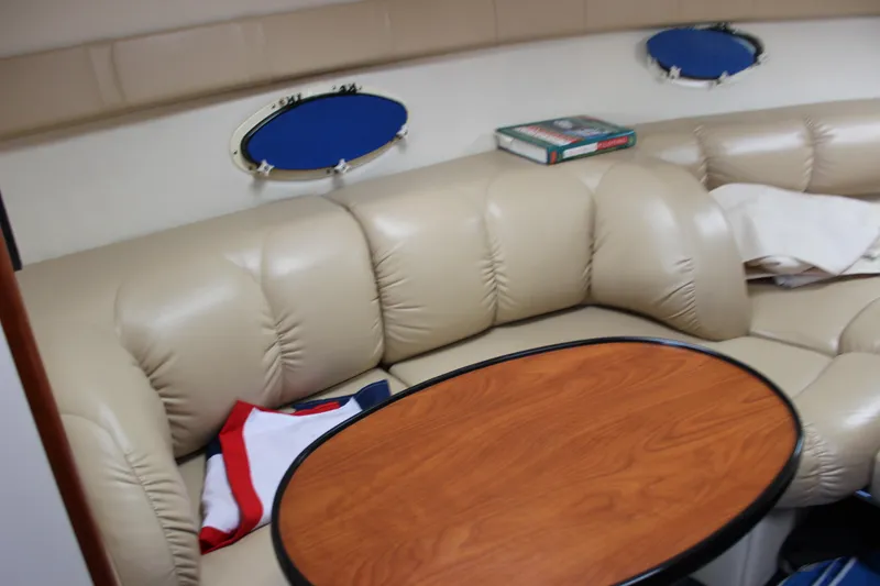 Slide: The Image of 2005 Larson Cabrio 310 interior with beige leather seating and wooden table. - 30