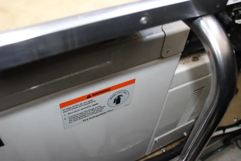 Slide: The Image of 2005 Larson Cabrio 310 engine compartment with warning label and metal railing. - 36