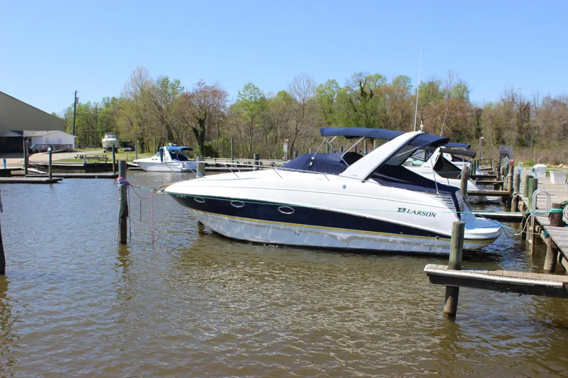 Slide: The Image of 2005 Larson Cabrio 310 boat docked at a marina on a sunny day. - 5