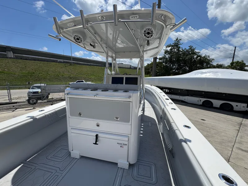Slide: The Image of 2021 Contender 32ST boat with T-top and console, docked under a clear sky. - 12