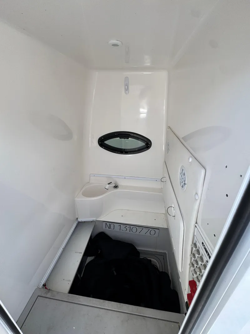 Slide: The Image of 2021 Contender 32ST boat interior with compact bathroom and oval window. - 13