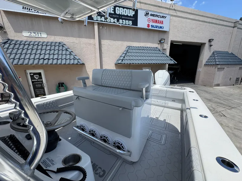 Slide: The Image of 2021 Contender 32ST boat interior with seating and controls, parked outside a marine service shop. - 14