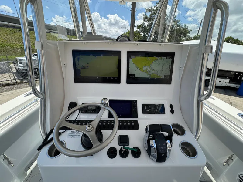 Slide: The Image of 2021 Contender 32ST boat dashboard with dual navigation screens and steering wheel. - 17