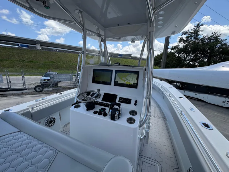 Slide: The Image of 2021 Contender 32ST boat cockpit with dual navigation screens and steering wheel. - 18