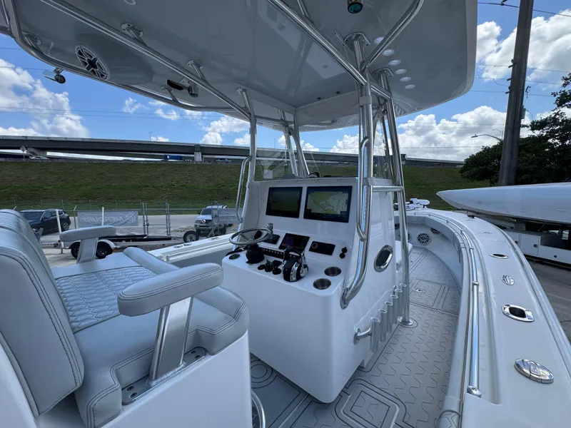 Slide: The Image of 2021 Contender 32ST boat interior with dual screens and seating under a clear sky. - 19
