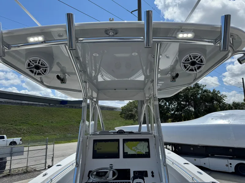 Slide: The Image of 2021 Contender 32ST boat console with electronics, speakers, and T-top under a blue sky. - 24